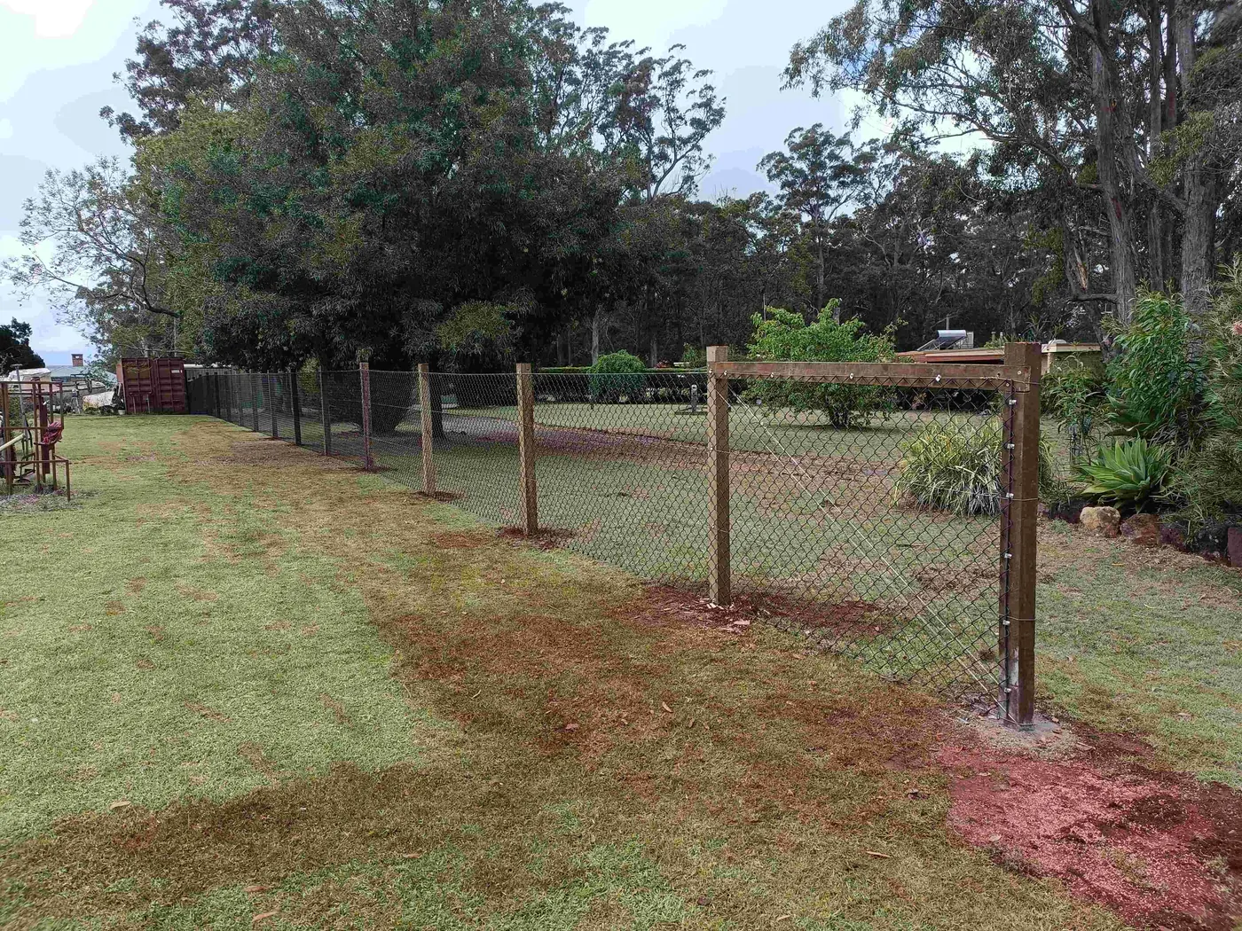 Timber posts and wire fencing across a grassy rural block
